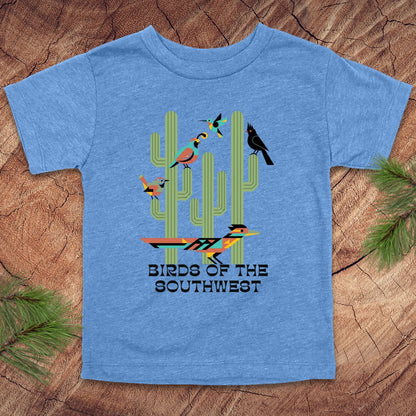 Blue toddler t-shirt with 'Birds of the Southwest' design featuring cacti and birds on a wooden surface.
