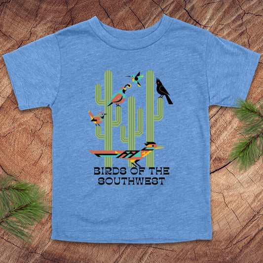 Blue toddler t-shirt with 'Birds of the Southwest' design featuring cacti and birds on a wooden surface.