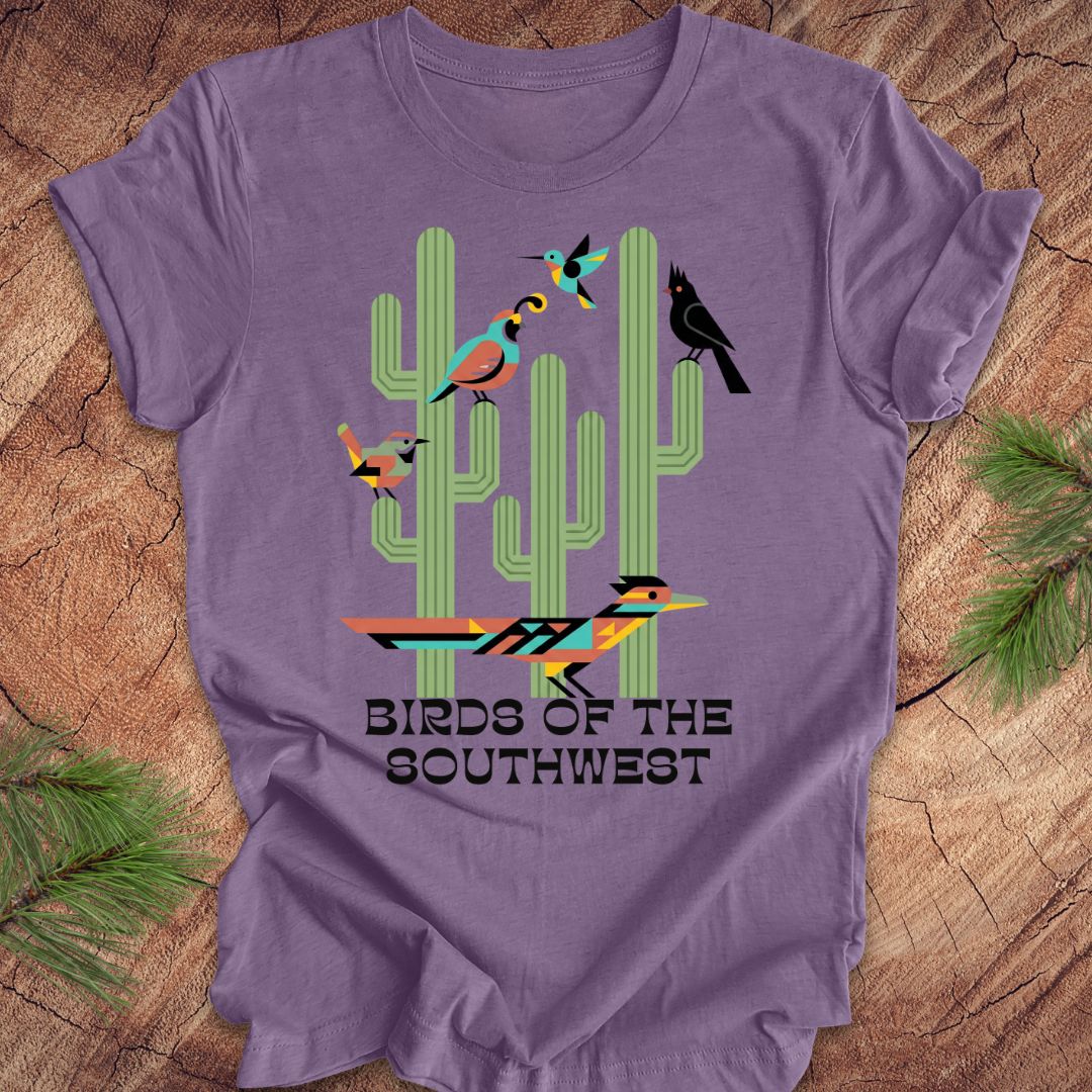 Purple t-shirt with cactus and bird design on a wooden surface