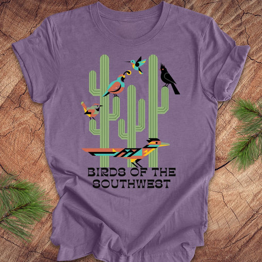 Purple t-shirt with cactus and bird design on a wooden surface