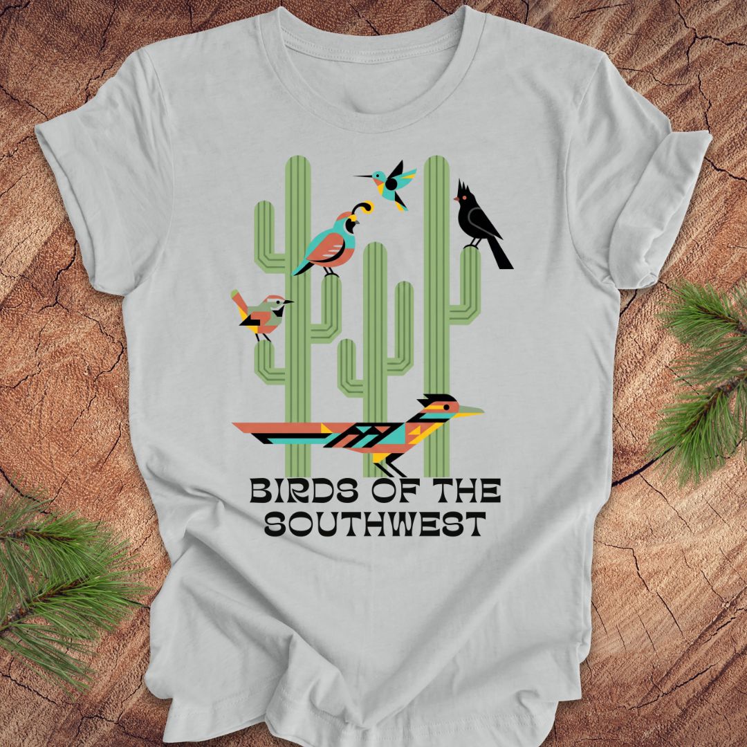 Gray t-shirt with 'Birds of the Southwest' design featuring cacti and birds on a wooden surface.