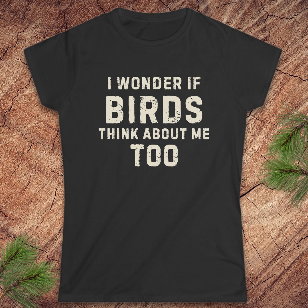 Black t-shirt with white text 'I wonder if birds think about me too' on a wooden surface.