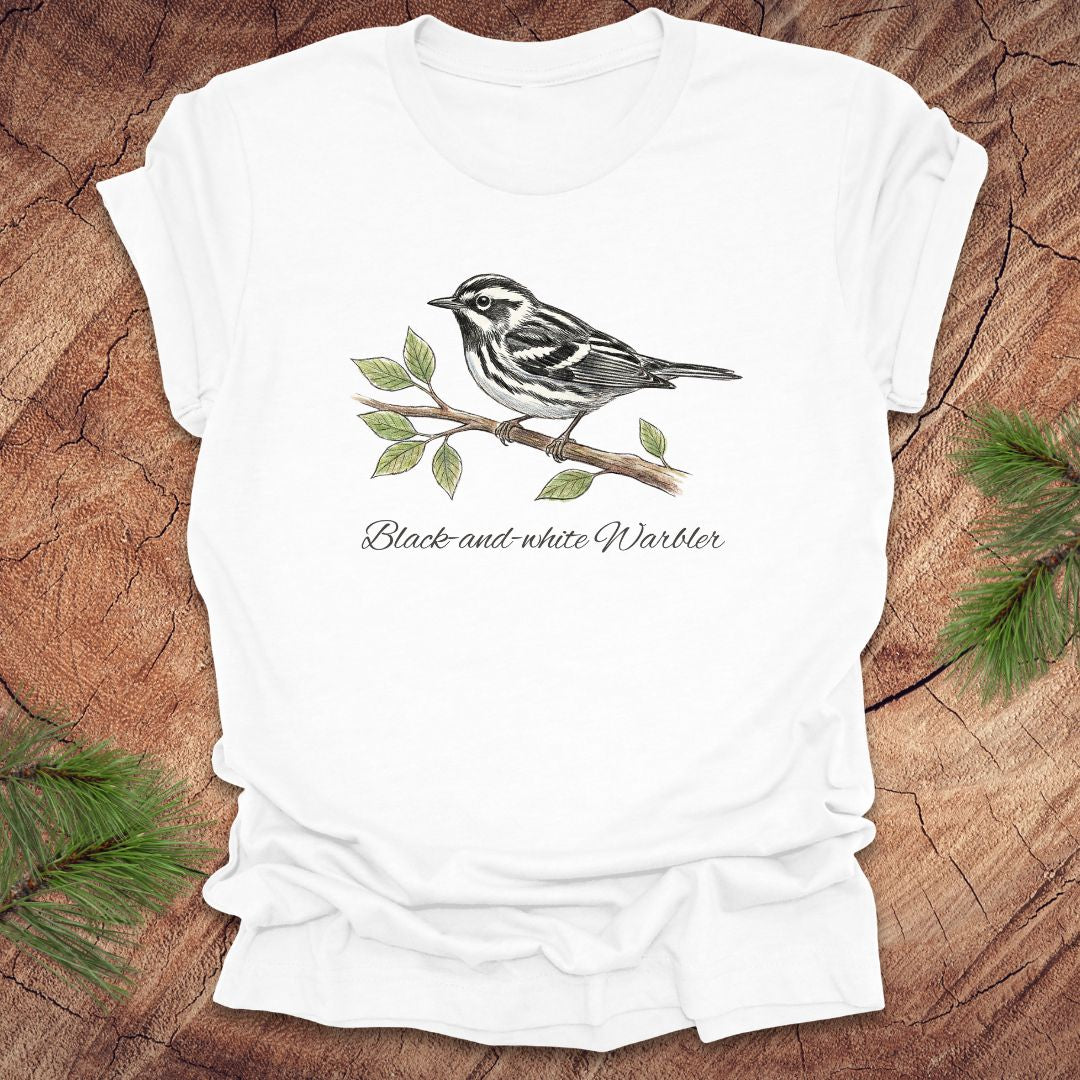 White t-shirt with black and white warbler design on a wooden surface