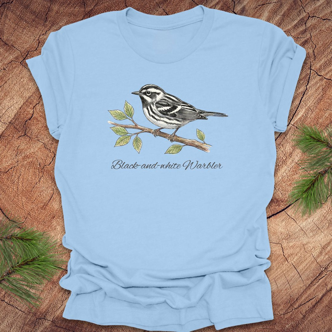 Light blue t-shirt with a black and white warbler design on a wooden surface