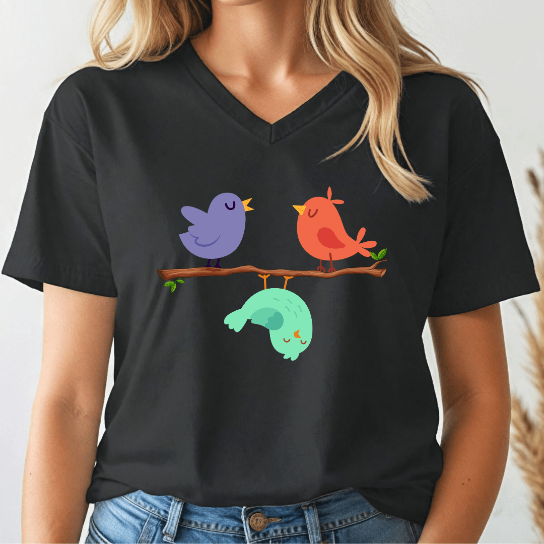 Person wearing a black v-neck t-shirt with colorful birds on a branch design.