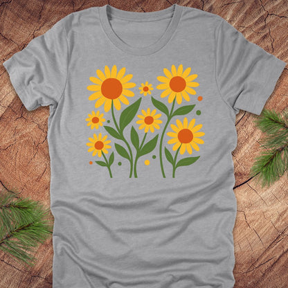 Gray t-shirt with yellow sunflower design on a wooden surface