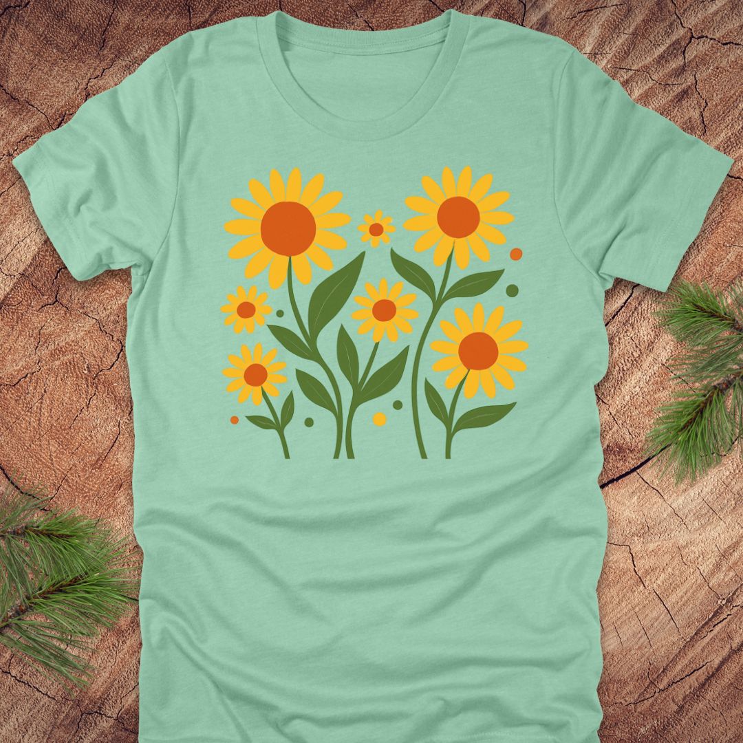 Mint green t-shirt with yellow sunflower design on a wooden surface