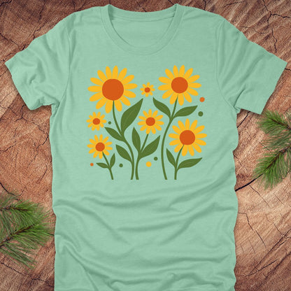 Mint green t-shirt with yellow sunflower design on a wooden surface