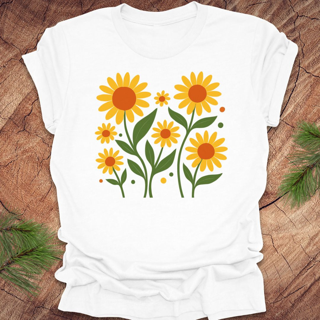 White t-shirt with yellow floral design on a wooden surface