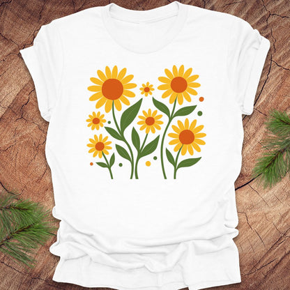 White t-shirt with yellow floral design on a wooden surface