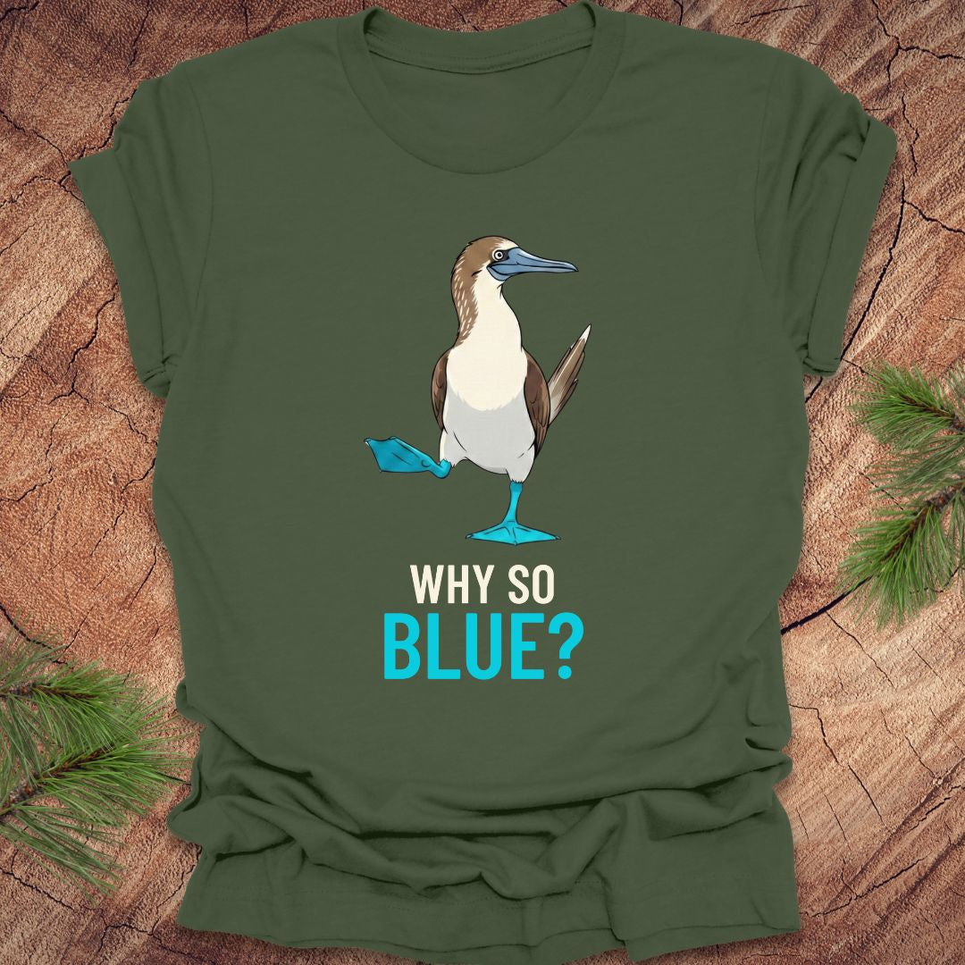 Green t-shirt with a blue-footed booby bird graphic and 'Why So Blue?' text on a wooden surface.