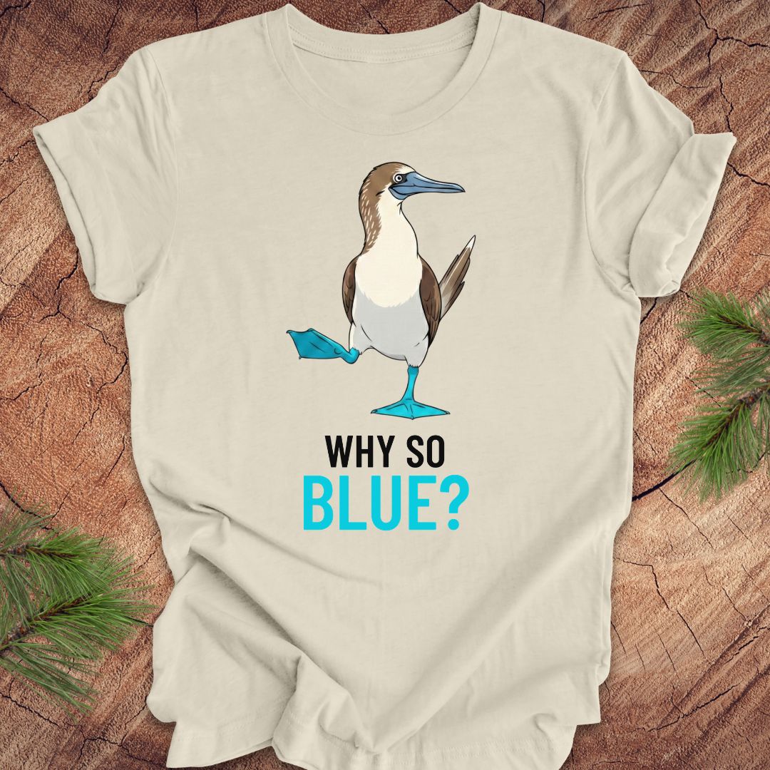 Beige t-shirt with a blue booby graphic and 'Why So Blue?' text on a wooden surface.