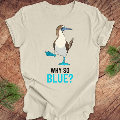 Beige t-shirt with a blue booby graphic and 'Why So Blue?' text on a wooden surface.