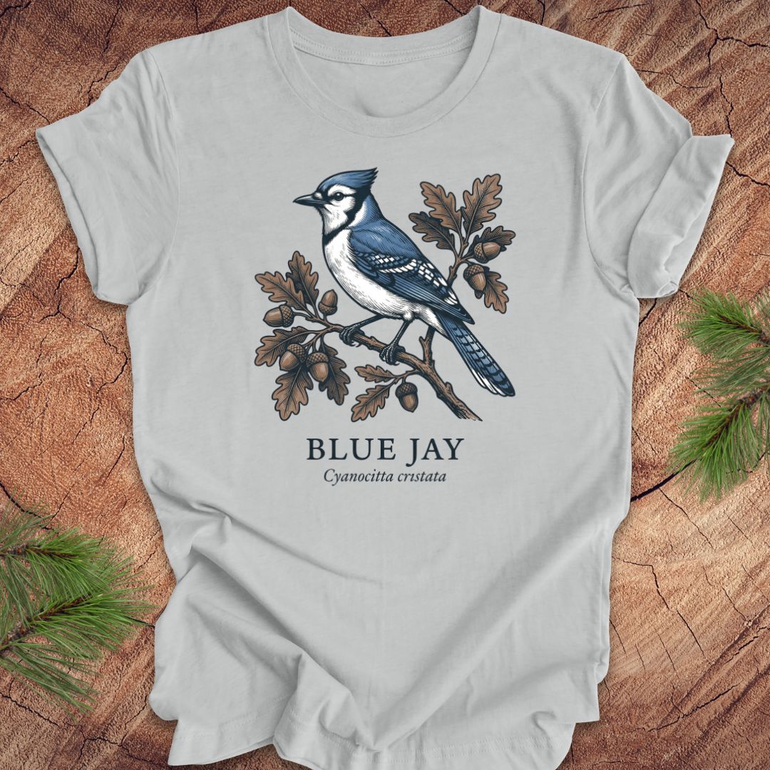 Gray t-shirt with a blue jay illustration on a wooden surface