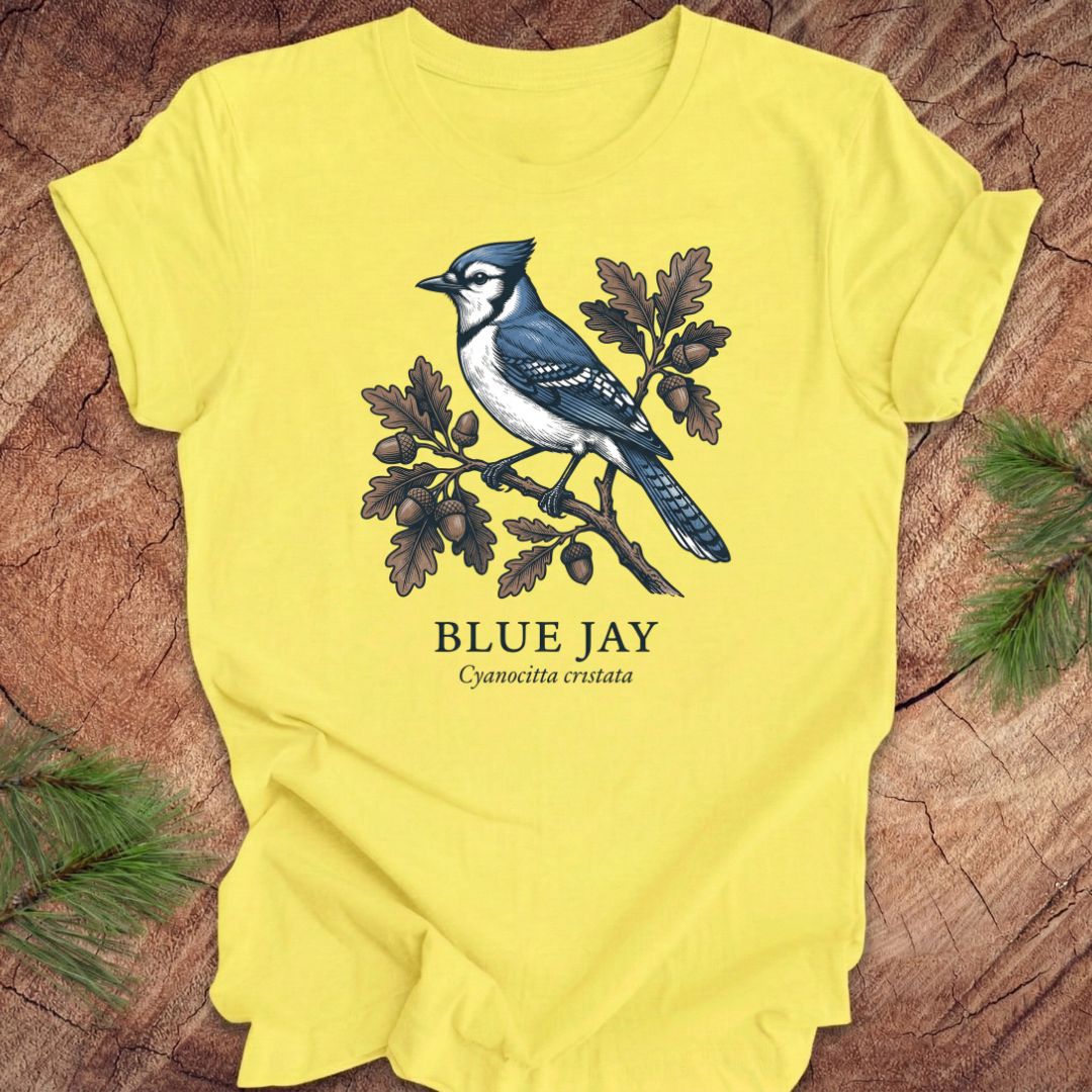 Yellow t-shirt with a blue jay graphic and text on a wooden surface