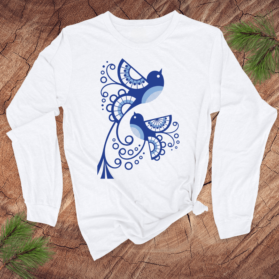 White long-sleeve shirt with blue abstract bird design on a wooden surface