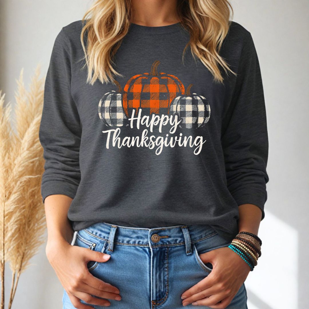 Person wearing a dark gray long-sleeve tshirt with 'Happy Thanksgiving' and plaid pumpkin design.