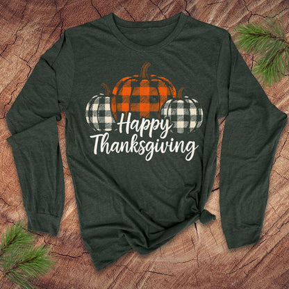 Green long-sleeve tshirt with 'Happy Thanksgiving' text and plaid pumpkins on a wooden surface.