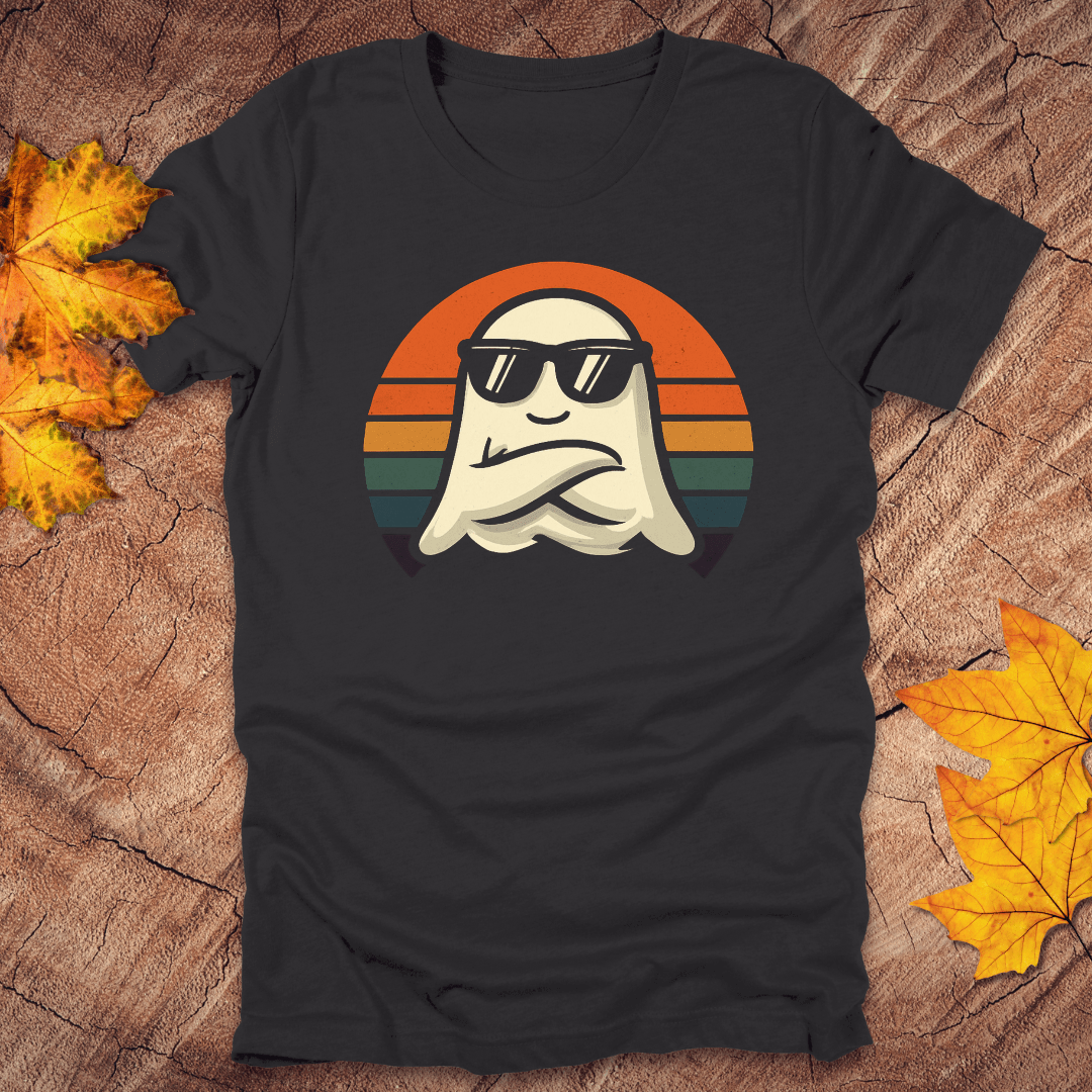 Dark gray t-shirt with a ghost wearing sunglasses design on a wooden surface with autumn leaves.