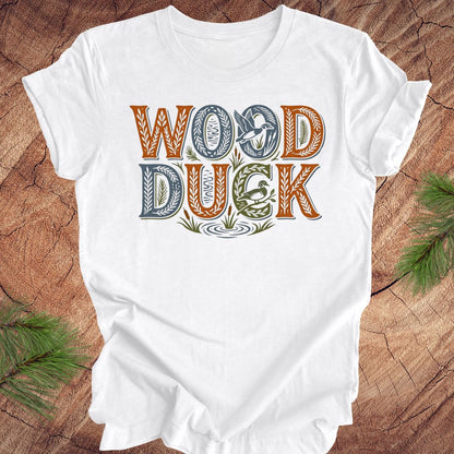 White t-shirt with 'Wood Duck' text on a wooden surface