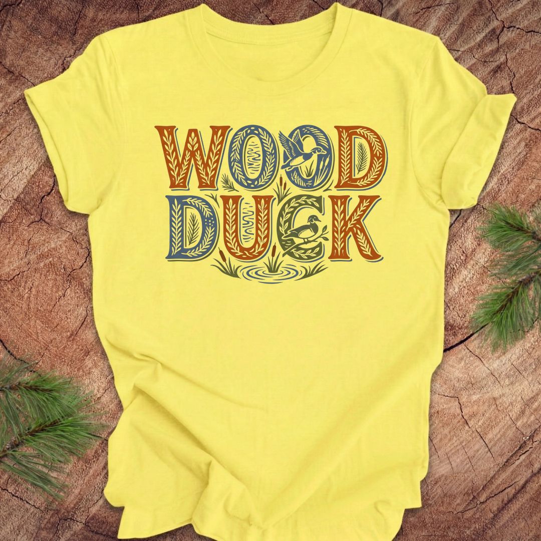Yellow t-shirt with 'WOOD DUCK' text on a wooden surface
