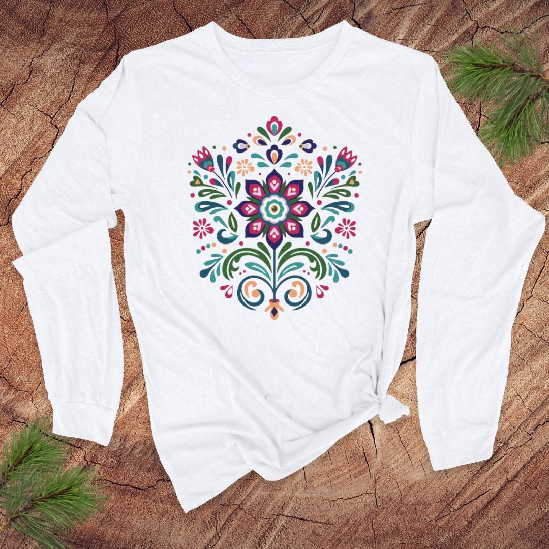 White long-sleeve t-shirt with a vibrant dutch inspired flower design on a wood background.