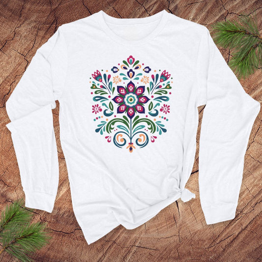 White long-sleeve t-shirt with a vibrant dutch inspired flower design on a wood background.
