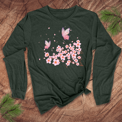 Green blue long-sleeve shirt with pink cherry blossom and butterfly design on a wooden surface.
