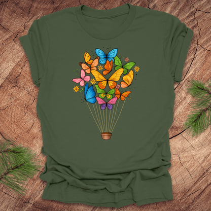 Green t-shirt with colorful butterfly design on a wooden surface