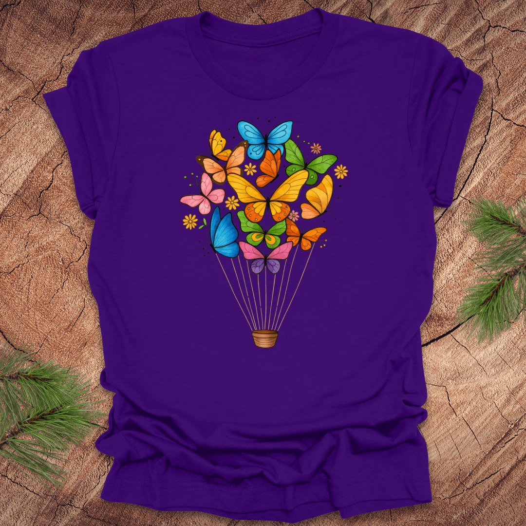 Purple t-shirt with colorful butterfly design on a wooden surface