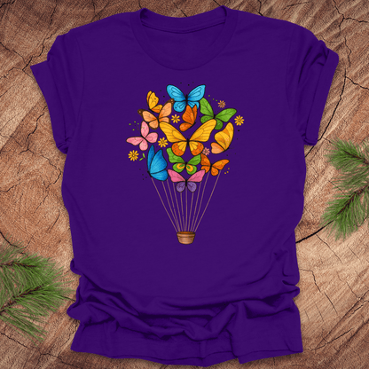 Purple t-shirt with colorful butterfly design on a wooden surface