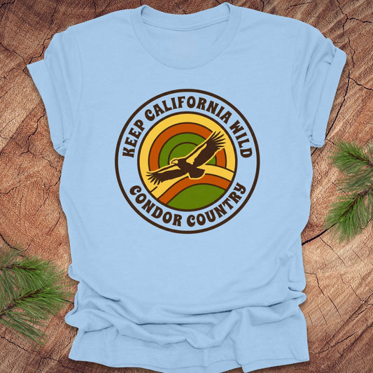 Light blue t-shirt with 'Keep California Wild Condor Country' graphic on a wooden surface.