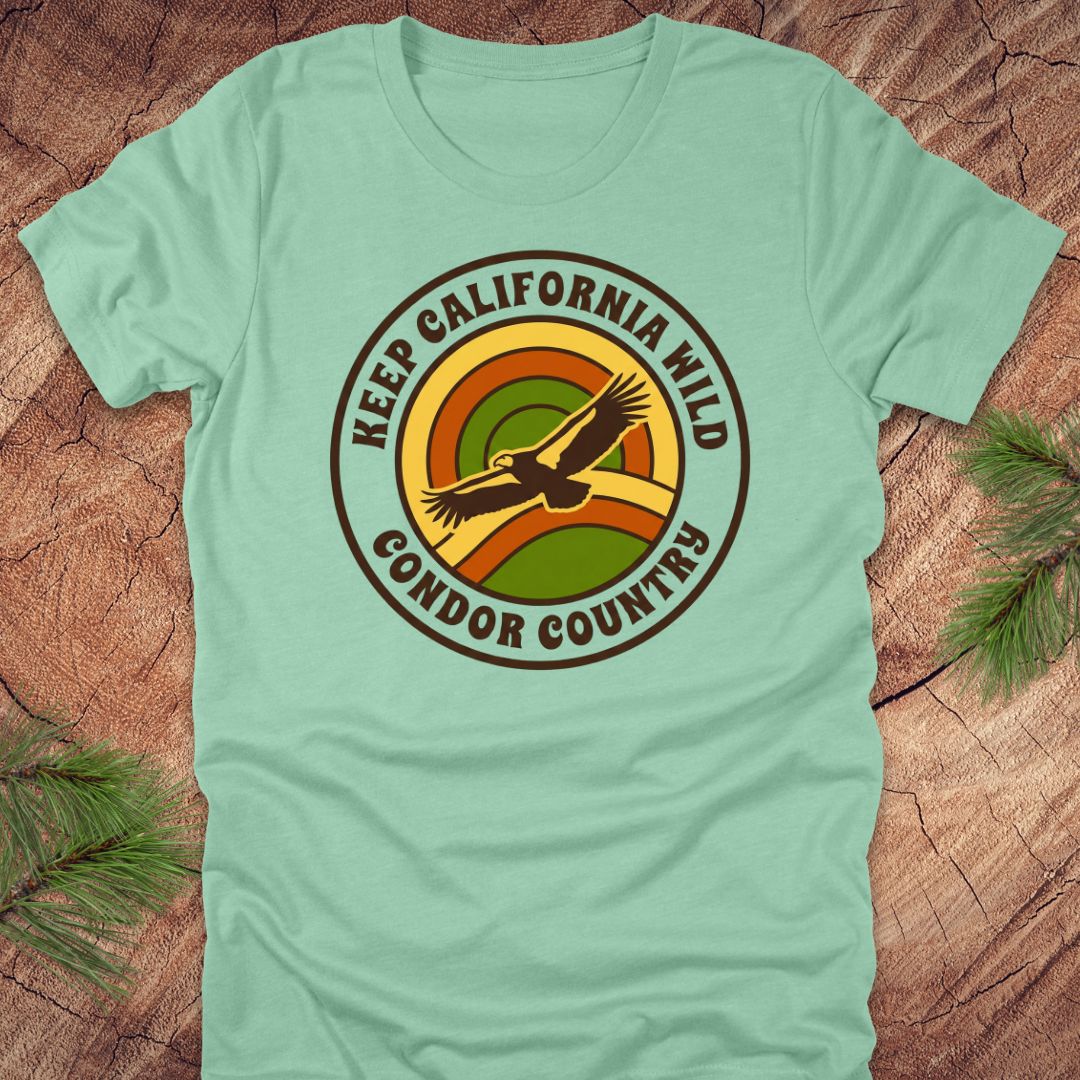Light green t-shirt with 'Keep California Wild Condor Country' graphic on a wooden surface.