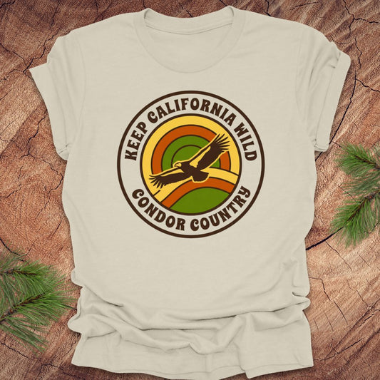 Beige t-shirt with 'Keep California Wild Condor Country' graphic on a wooden surface.