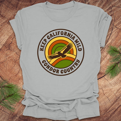Silver t-shirt with 'Keep California Wild Condor Country' graphic on a wooden surface.
