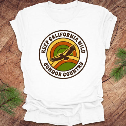 White t-shirt with 'Keep California Wild Condor Country' graphic on a wooden surface.
