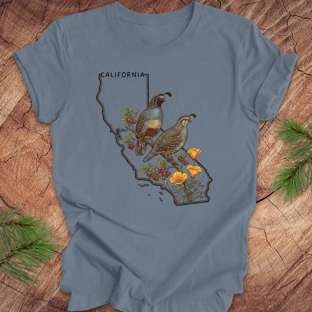 Blue t-shirt with California map design featuring quails and flowers on a wooden surface.