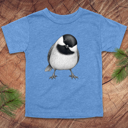 Blue toddler t-shirt with a chickadee design on a wooden surface