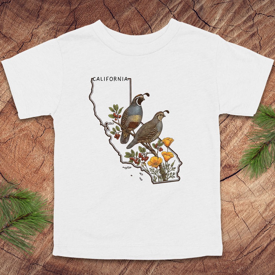 White toddler t-shirt with state outline of California and quails and flowers on a wood background.