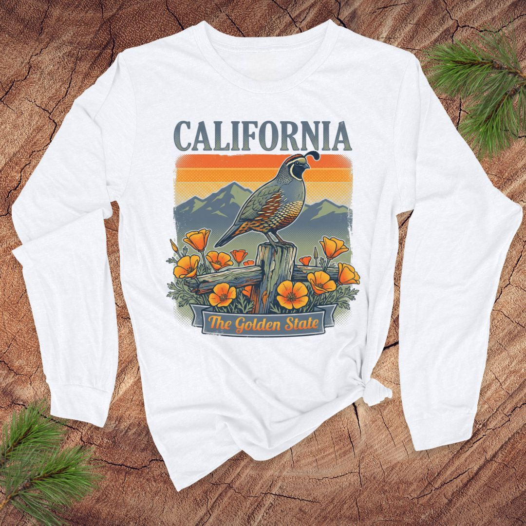 White long-sleeve shirt with California-quail and poppy graphic on a wooden surface