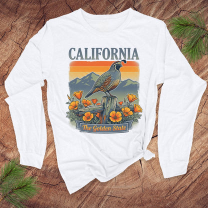 White long-sleeve shirt with California-quail and poppy graphic on a wooden surface
