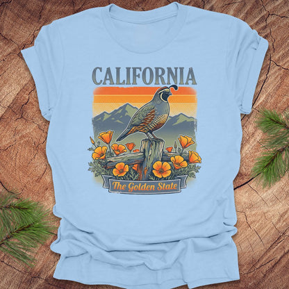 Light blue t-shirt with a California-themed graphic featuring a quail and poppies on a wooden surface.