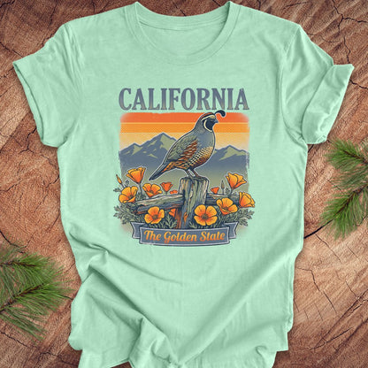 Mint green t-shirt with California-themed graphic on a wooden surface