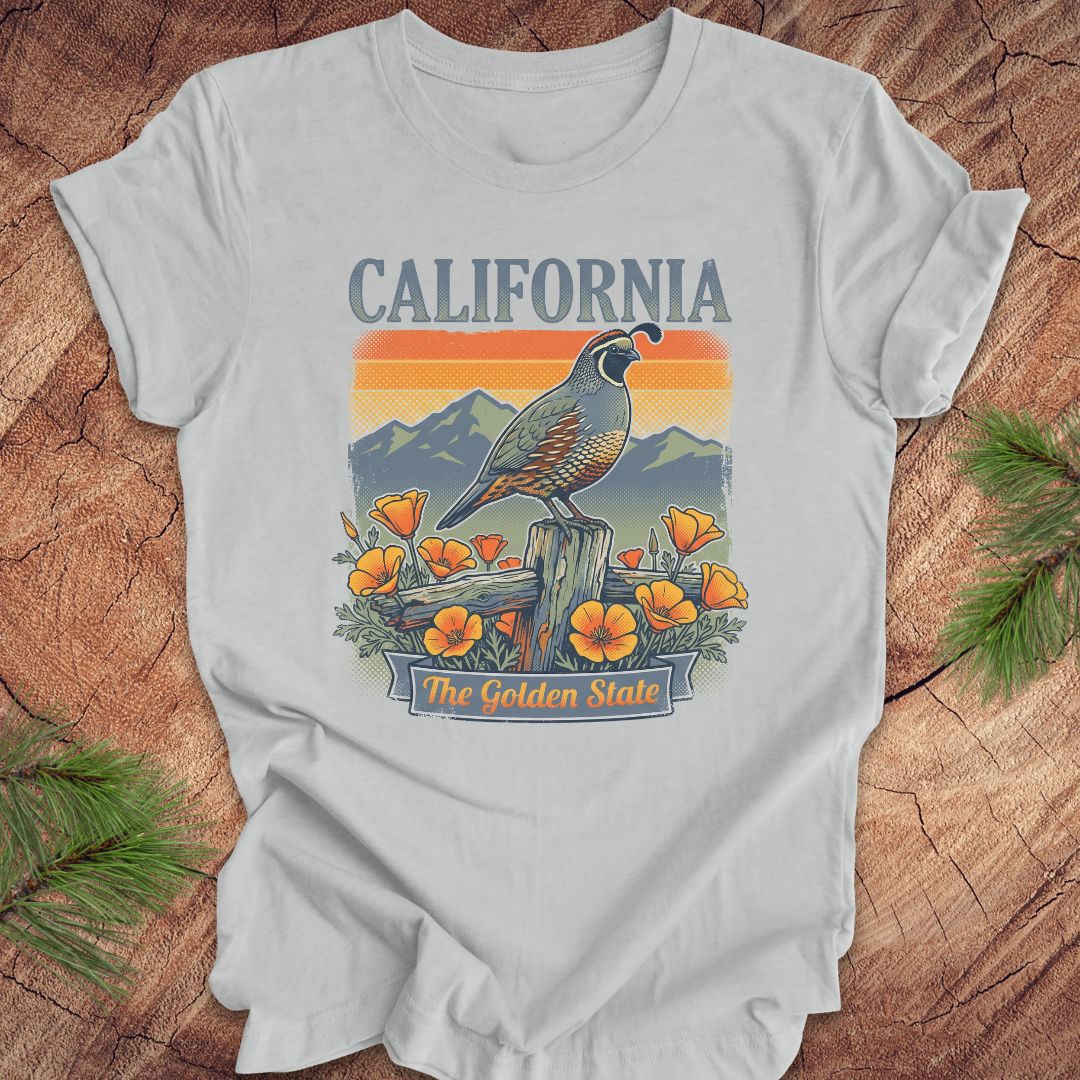 Gray t-shirt with California-themed design featuring a quail, mountains, and poppies on a wooden surface.