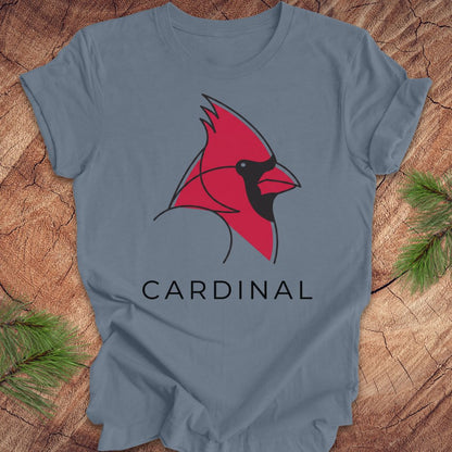 Blue t-shirt with a cardinal and text on a wood background.