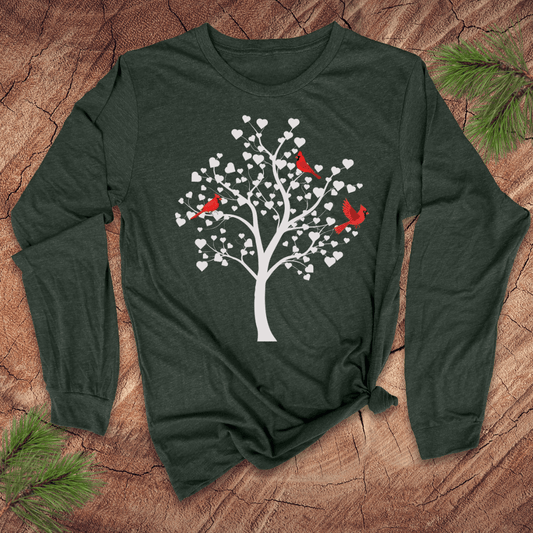 Green long-sleeve t-shirt with a white tree design featuring cardinals on a wooden surface.