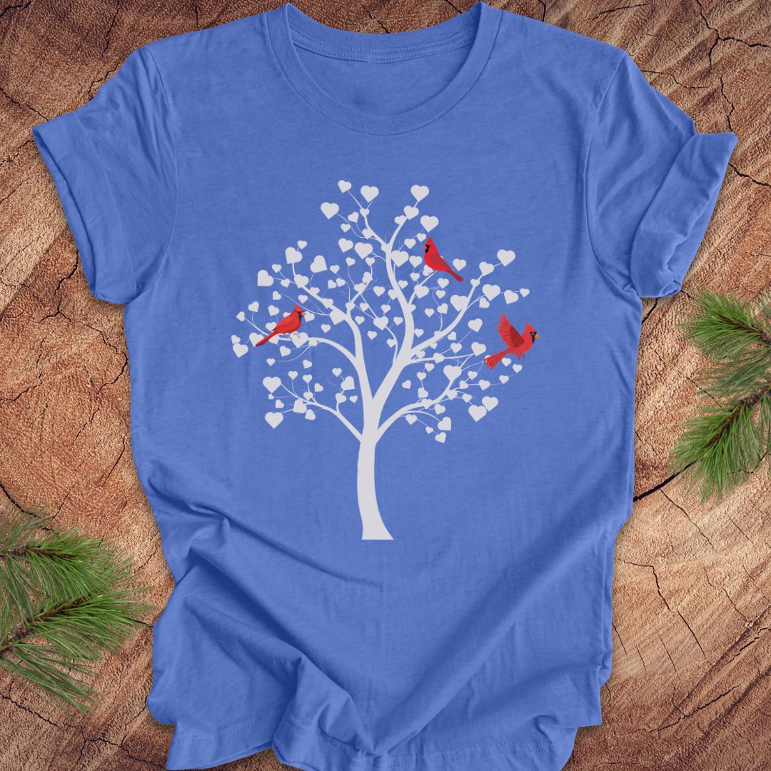 Blue t-shirt with a tree and birds design on a wooden surface