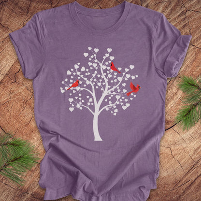 Purple t-shirt with a tree and birds design on a wooden surface