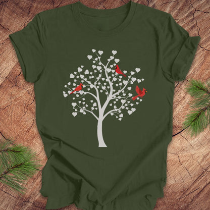 Green t-shirt with a tree and cardinal design on a wooden surface