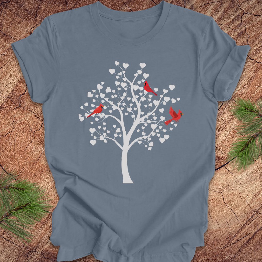 Blue t-shirt with a tree and red birds design on a wooden surface